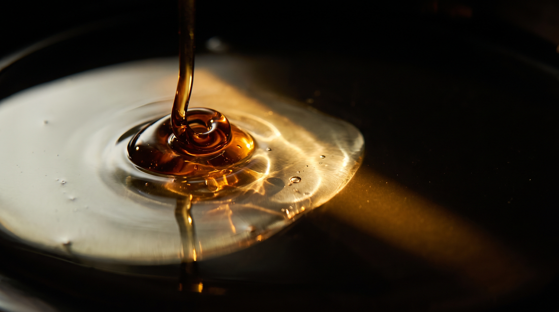زيت عطري كثيف بلون العنبر يلتقي بسائل ذهبي أخف — التركيز مرئيًا